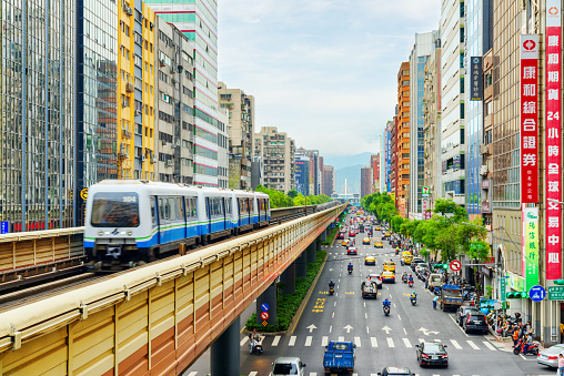 Taipei, Taiwan - April 26, 2019: Amazing view of train of the Taipei Metro passing above Fuxing Road. Viaduct of Wenhu line. Day traffic. Taipei is a popular tourist destination of Asia.