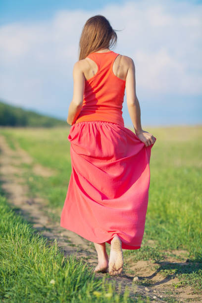 istock Relaxing beautiful woman walking alone on green grass in summer 1396201237