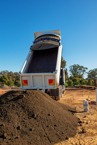 Dump truck unloading crushed gravel to work site
