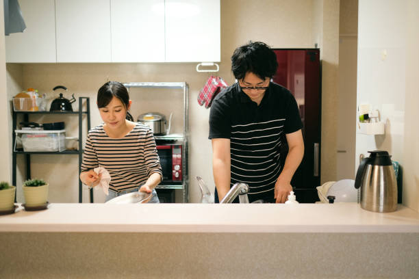 istock Couple washing dishes together in domestic kitchen 1396202144
