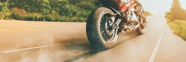 Motorcycle parked alone on a sunny road in the evening,panoramic banner concept