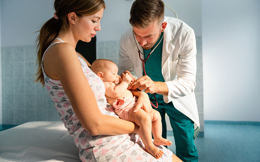 Happy pediatrician doctor examines baby. Healthcare, people, examination concept