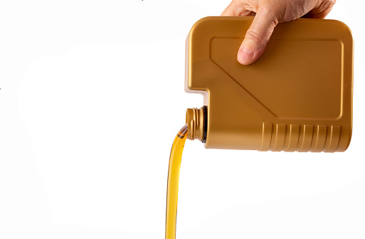 Pouring out motor oil on white background