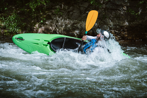 Man extreme kayaking in rapids.