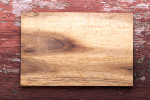 Empty cutting board on a wooden background. Top view. Space for text.