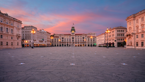 Panoramic cityscape image of downtown Trieste, Italy with main square at dramatic sunrise.