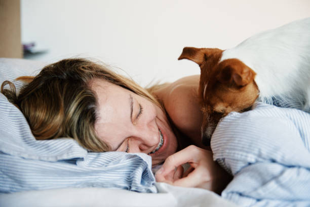 istock Woman sleeping in bed and play with her dog 1396211118