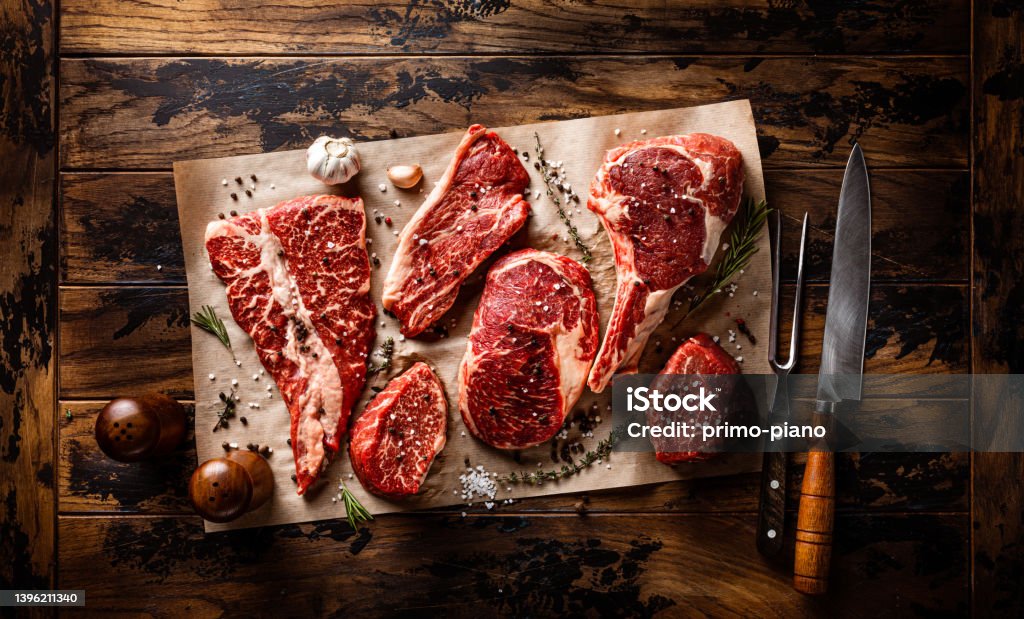 Assortment of raw meat cut with seasoning and utensils Assortment of raw meat cut with seasoning and utensils on wooden rustic board Pork Stock Photo