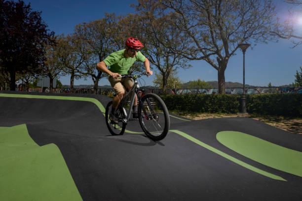 cycliste sur un circuit de piste de pompage passant par une zone de boost - bmx cycling bicycle cycling sport photos et images de collection