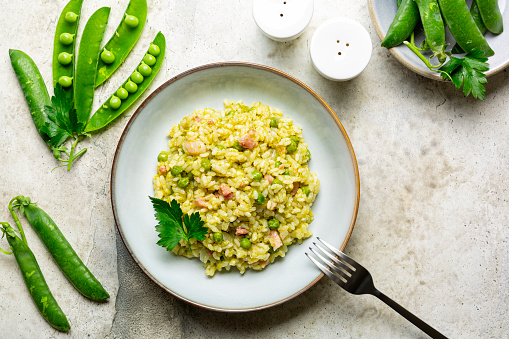 Italian, Venetian rice and spring green pea. Risi e bisi.  Spring dish made with Vialone nano rice, green peas, parsley and bacon. Ingredients. Horizontal image, copy space.