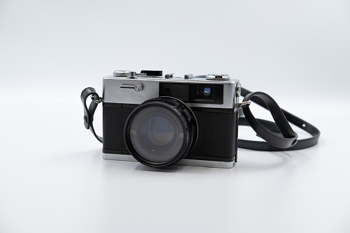 Digital mirrorless professional camera on wooden table with concrete wall as a background