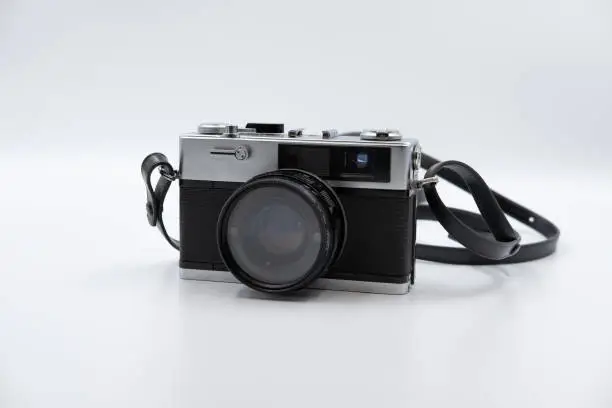 Photo of Isolated white background Beautiful vintage analog rangefinder film camera. 70's Decade film camera. Front view image.