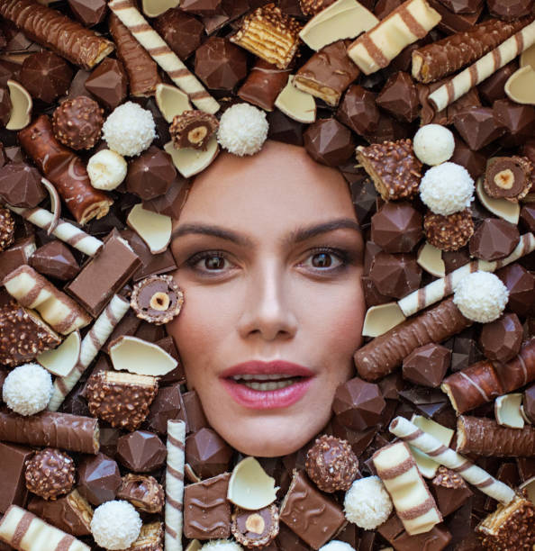 istock Cute woman with chocolate candy, beautiful face closeup 1396218032