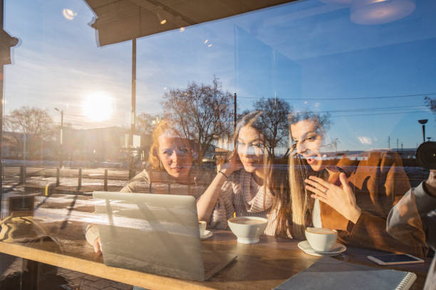 istock Three female friends using laptop in coffee shop 1396218105