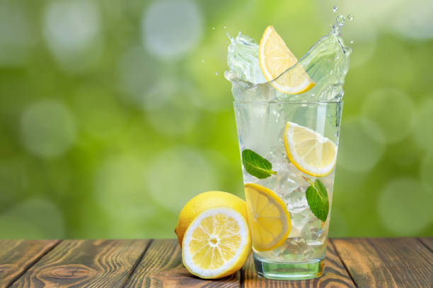 istock lemonade in glass with splash on wooden table 1396219397