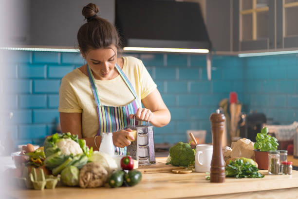 istock Young  woman Grating Cheese in her kitchen 1396219692