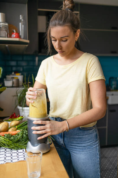 istock Young woman making a healthy smoothie for breakfast 1396219720
