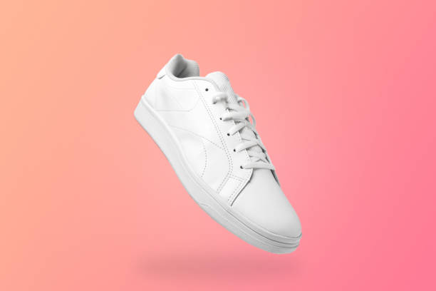 istock High angle view of white sneaker isolated on peachy background. 1396220256