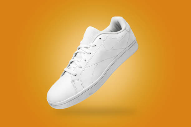 istock High angle view of white sneaker isolated on yellow background. 1396220261