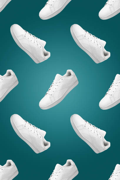 istock Pattern of white sneakers isolated on green background. 1396220267