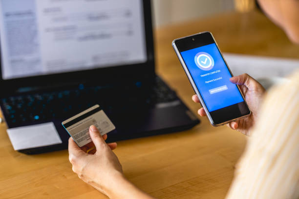 istock Young woman Paying Bills with mobile phone 1396220433