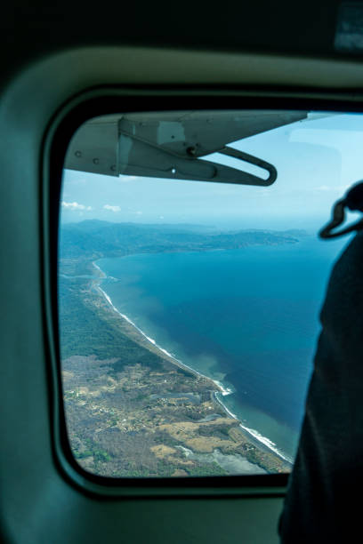 istock Airplane porthole window with the coast 1396220579