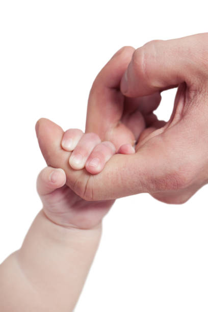 The tiny hands of a newborn baby held in the mother's hands with love and warmth.