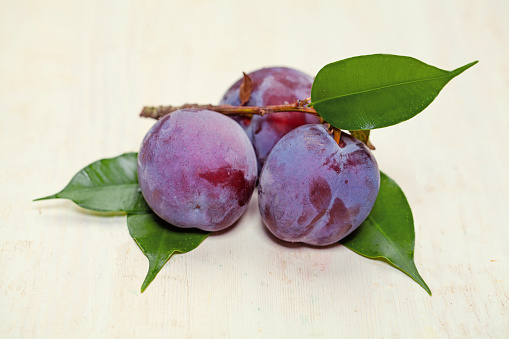 Plums on white vintage wooden table. Vegetarian food. Healthy food, delicious fruit
