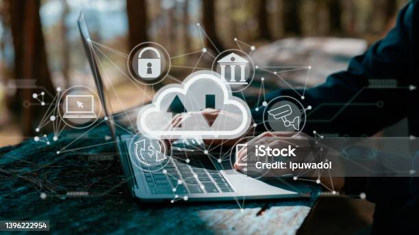A Guy Works On A Laptop While Holding A Cloud Computing Diagram Data Storage Networking And Internet Service Principles Are All Based On Cloud Technology Stock Photo - Download Image Now