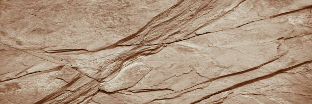 istock Light brown rock texture. Rough mountain surface. Close-up. Beige stone background with space for design. Web banner. 1396225024