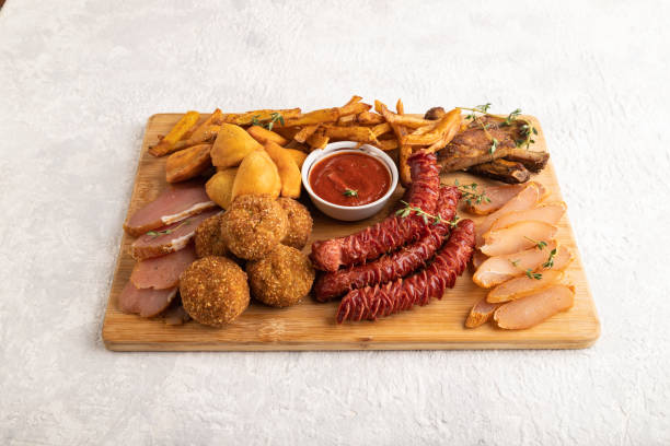 istock set of snacks: sausages, fried potatoes, meat balls, dumplings, basturma. Side view, copy space. 1396228682