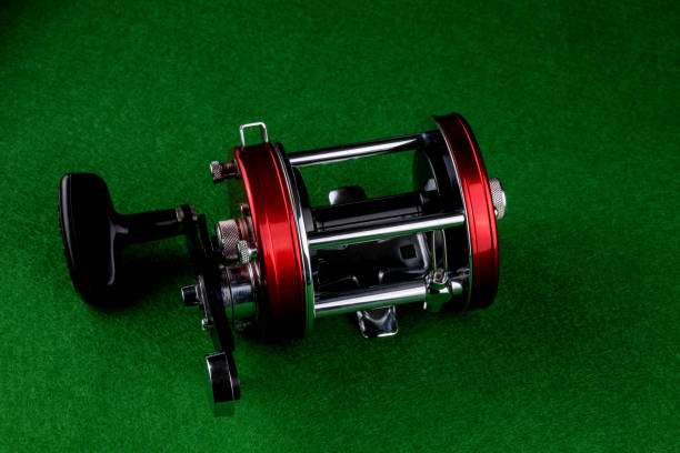 Multiplier type fishing reel isolated on a green felt table top
