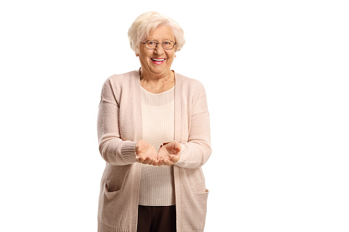 Elderly woman holding something imaginary in both hands and smiling isolated on hite background