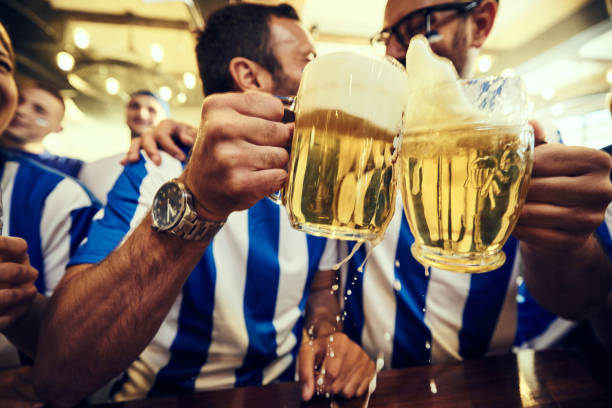 close up of male sports fans toasting with beer in a pub. - fan sport football male imagens e fotografias de stock