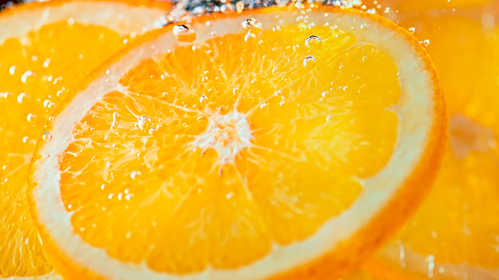 Close-up of orange slices in water.