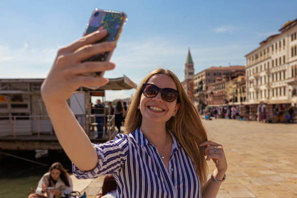 istock Female tourist in Venice taking selfies and smiling 1396244346