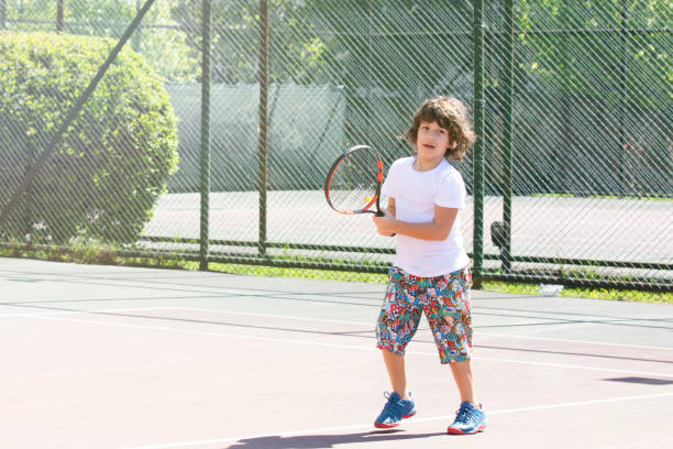 istock Happy boy playing tennis outdoors with a friend. 1396244440