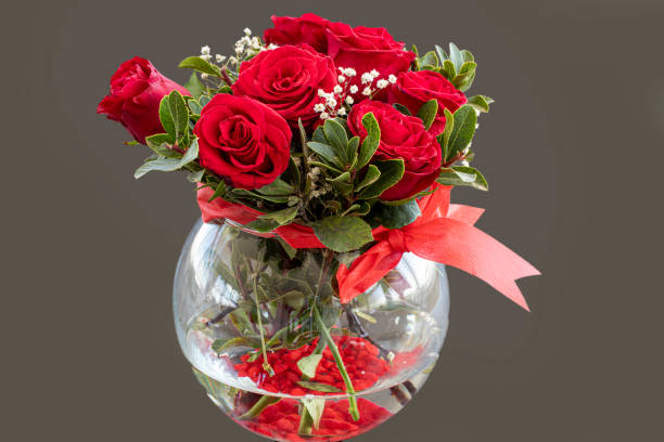 istock Red roses in glass vase isolated on background. 1396247142