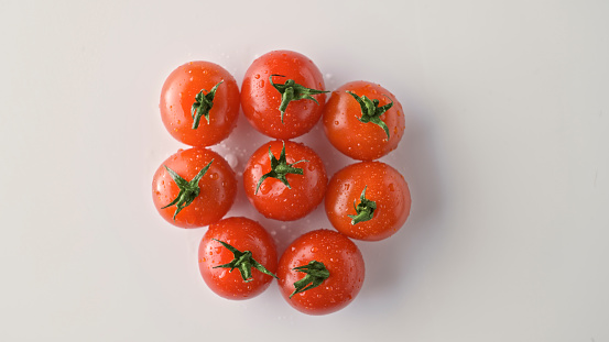 Close-up of fresh cherry tomatoes against white background.