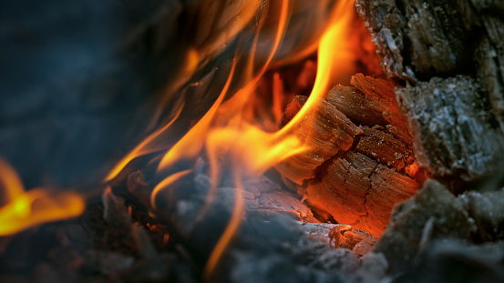 Close-up of burning wood in fire at night.