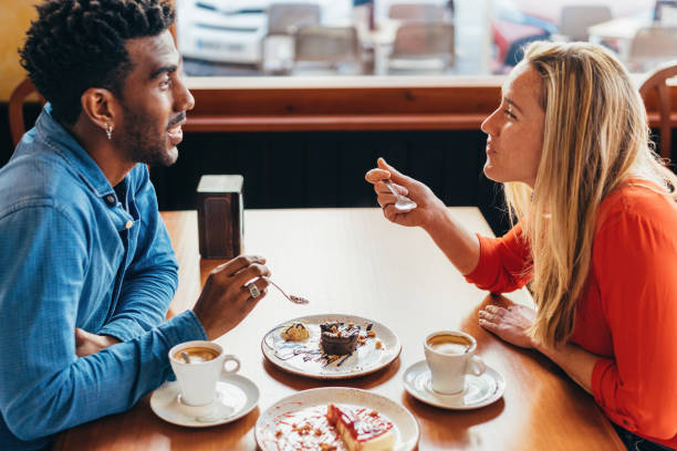 istock interracial couple having coffee and cake sitting at a table in a coffee shop 1396247630