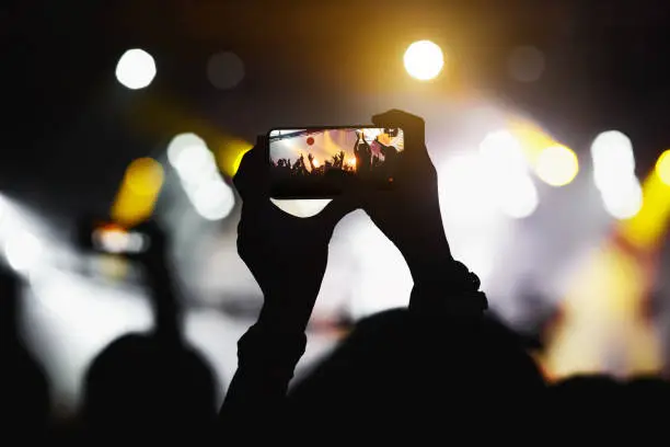Photo of The fan taking a photo of a concert at a festival.