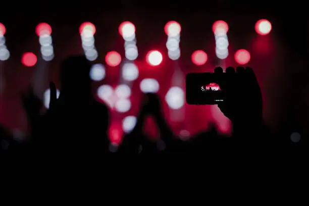 Photo of The fan taking a photo of a concert at a festival.