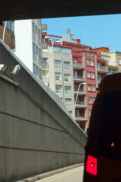 Urban road tunnel exit, car driving.