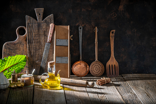 Rustic kitchen background with copy space on wood table with kitchenware and cutting boards with a light beam