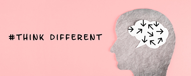 Think different stands on the pink background, head with brain, being a nonconformist, standing out from the crowd, creative and visionary concept