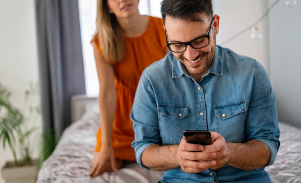 young couple with smartphone having quarell and marriage conflict because of cheating - quarell imagens e fotografias de stock