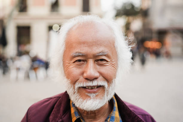 istock Asian senior man smiling on camera outdoor - Focus on face 1396258506