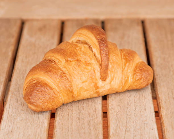 istock One croissant lies on a wooden table. 1396258548