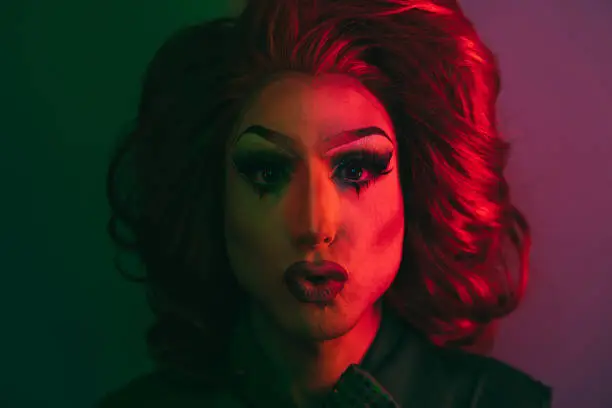 Photo of Drag queen looking at camera with neon color lights inside studio - Lgbtq concept